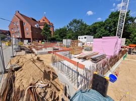Bautenstand zum 28.05.2025: Die Baustelleneinrichtung ist vollständig abgeschlossen, und die Arbeiten am Spezialtiefbau sowie an den Erdarbeiten sind bereits weit fortgeschritten. Im Kellergeschoss wurden die Rohbauarbeiten erfolgreich abgeschlossen, erste Entwässerungsmaßnahmen sind ebenfalls umgesetzt. Die Bauarbeiten verlaufen planmäßig, und die nächsten Schritte – wie der Beginn des Hochbaus – stehen kurz bevor.