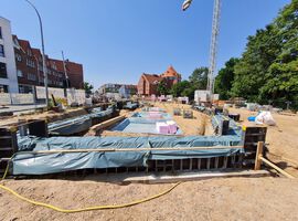 Bautenstand zum 28.05.2025: Die Baustelleneinrichtung ist vollständig abgeschlossen, und die Arbeiten am Spezialtiefbau sowie an den Erdarbeiten sind bereits weit fortgeschritten. Im Kellergeschoss wurden die Rohbauarbeiten erfolgreich abgeschlossen, erste Entwässerungsmaßnahmen sind ebenfalls umgesetzt. Die Bauarbeiten verlaufen planmäßig, und die nächsten Schritte – wie der Beginn des Hochbaus – stehen kurz bevor.